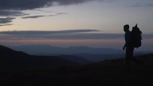 Backpacker Silhouette Hiking on Mountain During Sunrise
