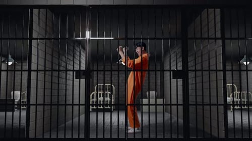 Full Body Side View Of Prisoner With Broken Handcuffs Screaming Goal Celebrating In Prison