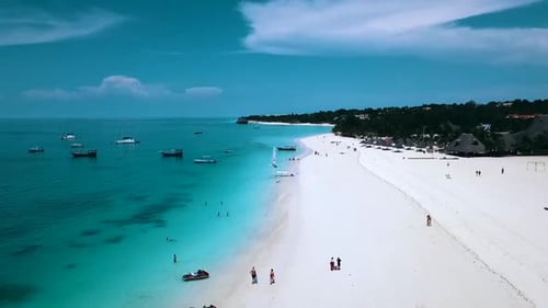Fantastic aerial flight fly forwards drone shot over crystal clear turquoise water white sand beach