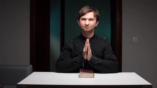 Adult Praying with Rosary Beads Indoors
