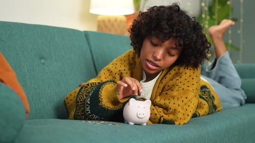 Saving Money Investment for Future African American Girl Putting Money Coin in Pink Piggy Bank