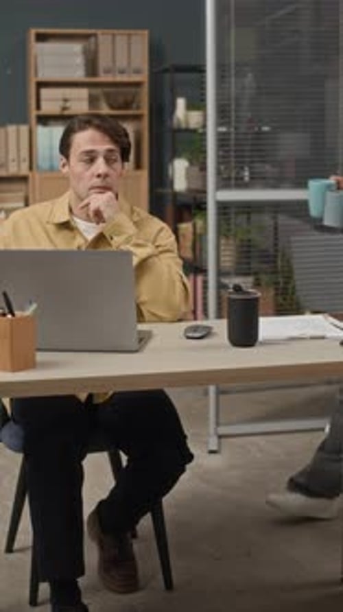 Young Multiethnic Male Colleagues Coworking on Project at Office Desk