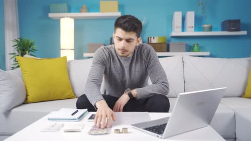 Joven estresado mirando a la cámara calculando sus deudas acumuladas y estresándose.