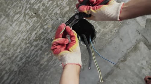 Electrician wiring electrical outlet in construction site