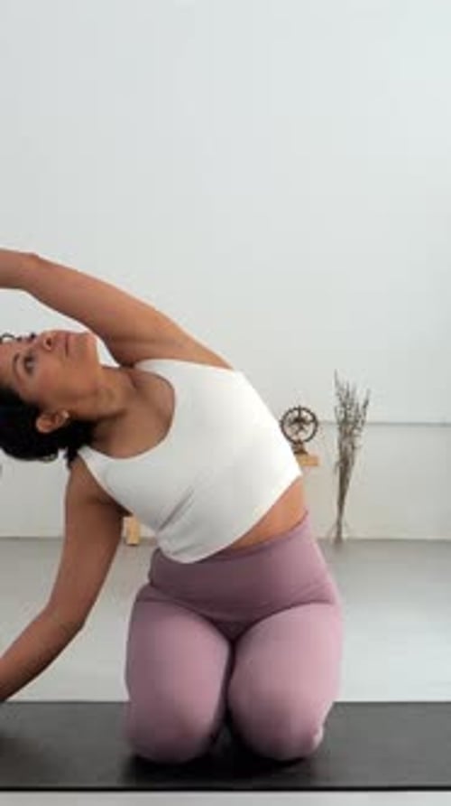 Vertical videoYoung Latin Woman Practicing Pilates in a Yoga Studio