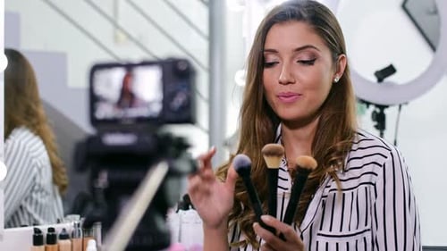 Joven bloguera haciendo un Vídeo para su blog de belleza sobre cosméticos.