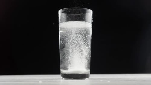 Effervescent Tablet Dissolving in Glass of Water