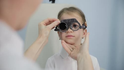 Optometrist Fitting Test Glasses on Young Patient