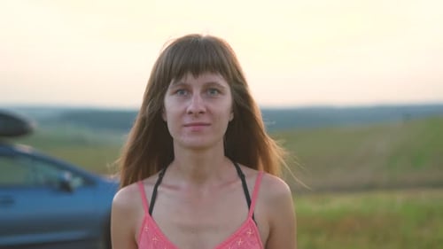 Young Woman Walking Alone on Green Field During Road Trip in Summer