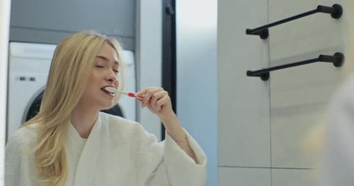 Woman Brushing Teeth in Modern Bathroom