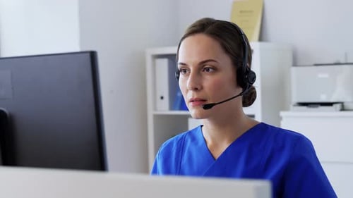 Woman Wearing Headset Works at Computer in Office