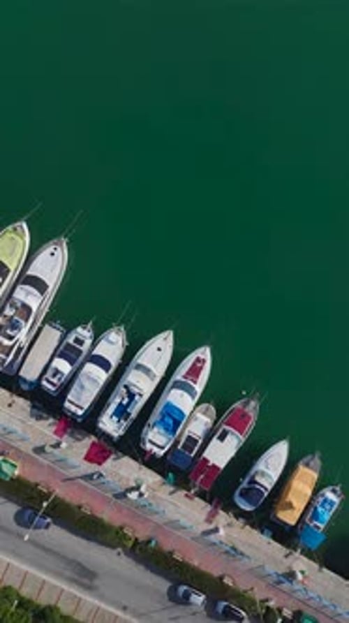 Vertical Video of a Port With a Variety of Boats and Yachts Captured From Above With Tourists