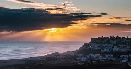 Cielo dorado: puesta de sol sobre una ciudad costera en Marruecos: Landscape Time Lapse