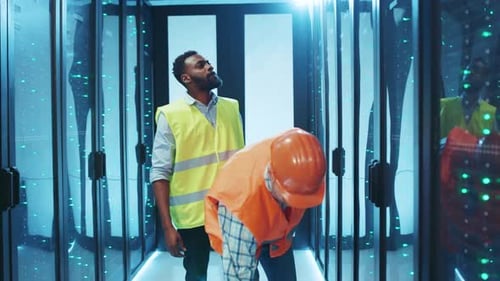 Two Dedicated Construction Workers Can Be Seen in a Vibrant NeonLit Environment Working Diligently