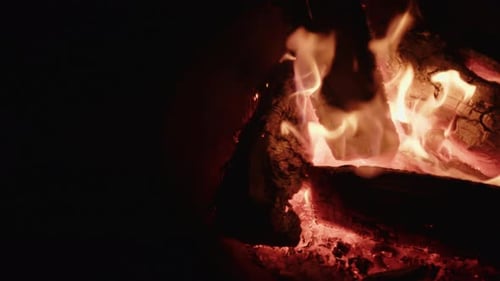 Glühende Flammen von brennendem Brennholz am Lagerfeuer in der Nacht