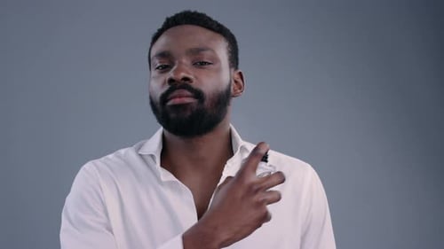 Portrait of Sexy Handsome Afroamerican Young Man in Shirt Applying Cologne Smelling Nice Aroma