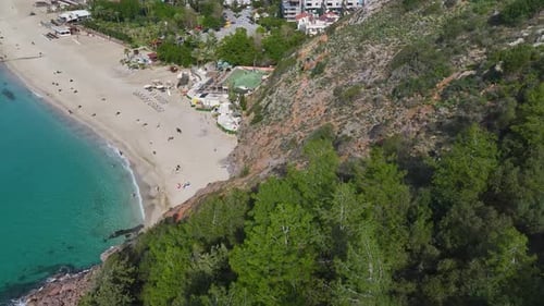 Aerial Video of a White Sand Beach Club With a Bar Wooden Deck and Palm Trees Overlooking the
