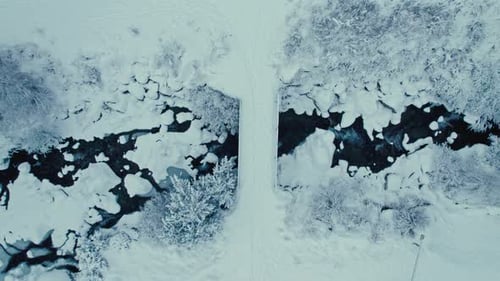 Top Down Shot of a Snowy Bridge Over the Frozen River