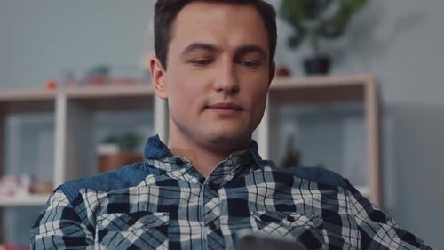 An Individual Who is Engaged with a Mobile Device While in a Casual and Relaxed Setting