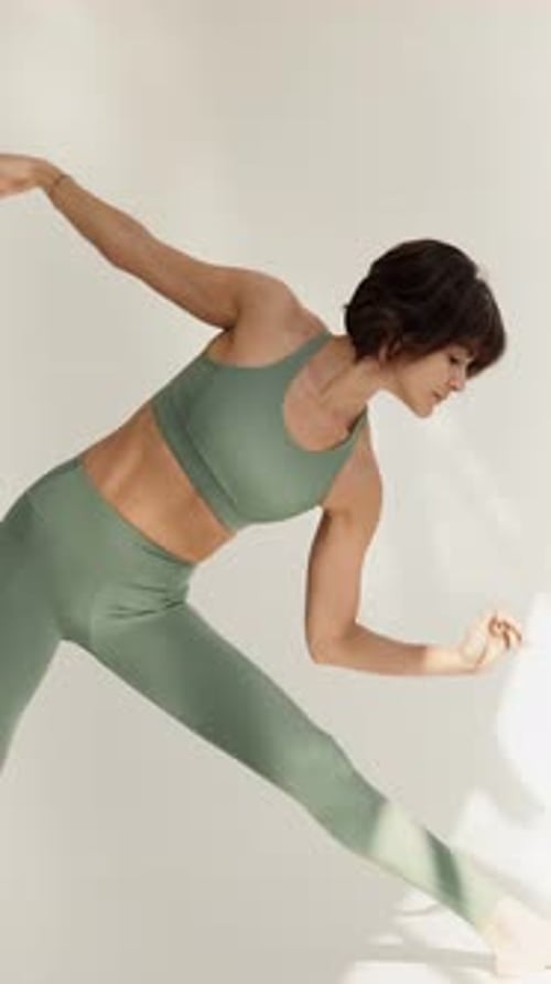 Woman Practices Yoga in Light Green Athleisure