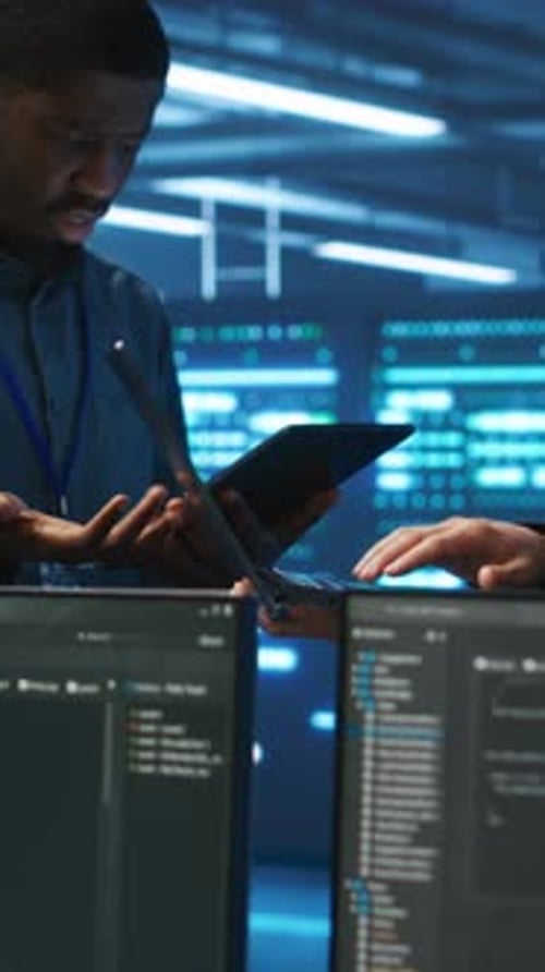 Vertical Video Coworkers Examining Equipment in Data Center Ensuring System Security