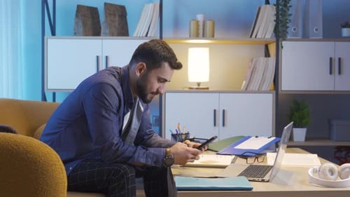 Man Relaxing on Couch Using Smart Phone