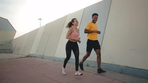 Fit Couple Running and Chatting Outdoors