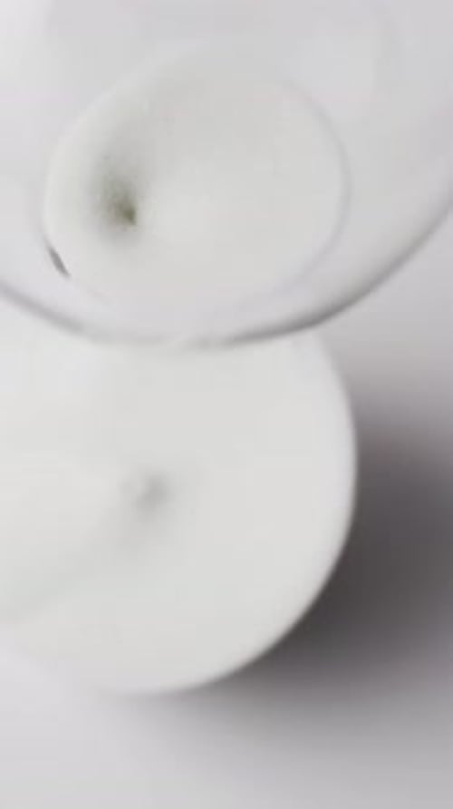 Vertical video of hourglass with sand pouring, copy space on white background