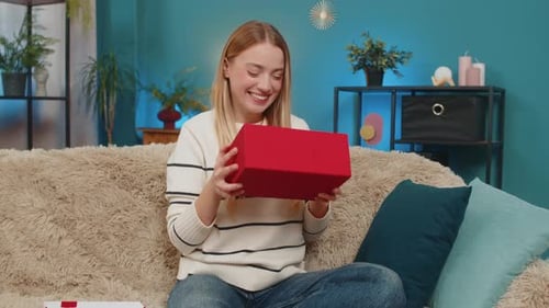 Woman Opening Gift Box with Enthusiasm Indoors