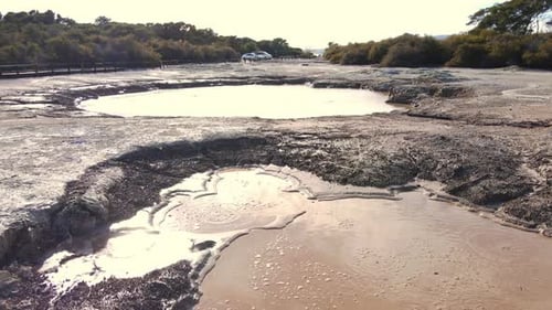 Low drone flyover of Bubbling Volcanic Lake mud pools. Geyser in geothermal volcanic park, New Zeal