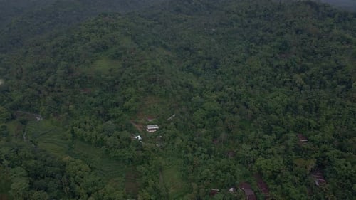 Aerial view of rural landscape of Indonesian with view of endless jungle on the hills in foggy morni