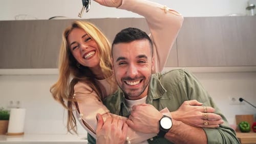 Excited Couple Holding Keys in Modern Kitchen