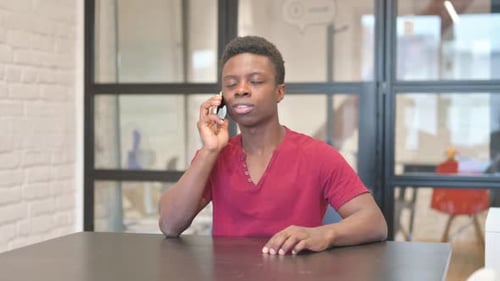 Young African Man Talking on phone in Office