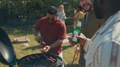 Adults Barbecue Together in Sunny Backyard
