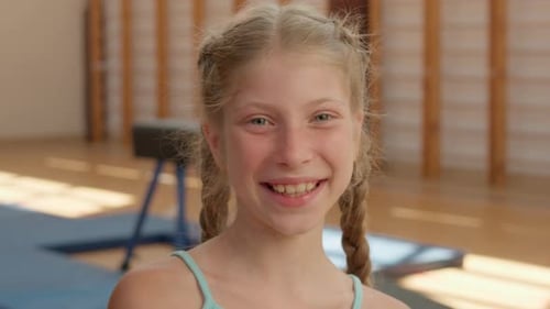 Smiling Girl with Braids in Gymnastics School Gym