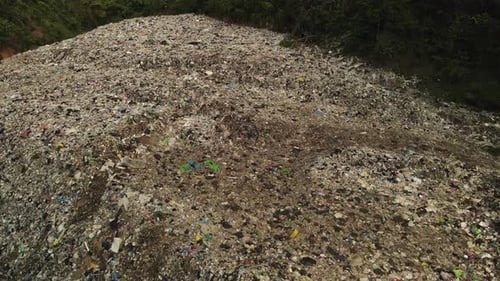 Aerial descending footage of Land fill garbage dump in the tropics in Thailand