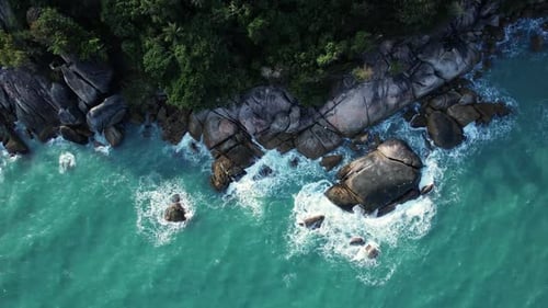 A Stunning Aerial View of Calm Blue Waters and a Rocky Shoreline Inviting Exploration