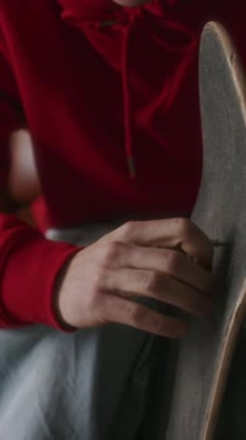 Person Adjusts Skateboard Using Skate Tool Close Up