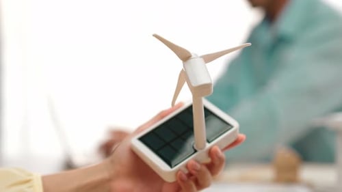 Business people with wooden block and windmill model on the table. Delineation.