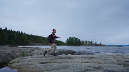 Carefree Man Tourist Hiking In Beautiful Landscape On Shore On Lake In Gloomy Cloudy Weather