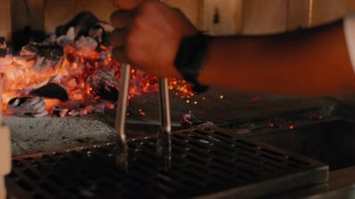 Raking coals into a wood fired grill