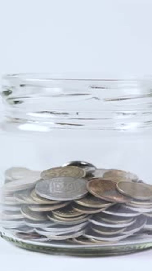 Coins Falling Into Jar of Savings