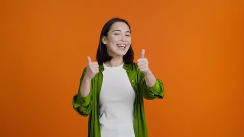 Enthusiastic Young Adult Woman Giving Thumbs Up