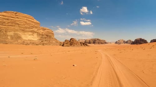 Desert Landscape with Towering Rock Formations and a Track Leading Into the Distance Wadi Rum Jordan