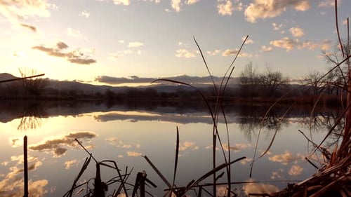 Reflection of sunset and clouds over lake surface