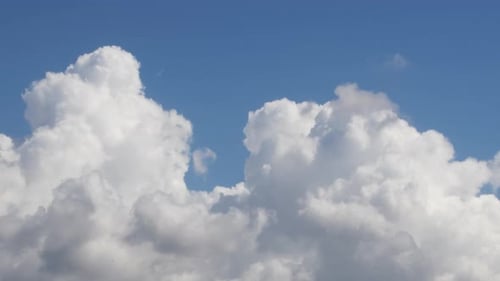 Fluffy White Clouds Moving Across a Bright Blue Sky