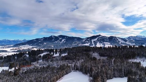 Nature of the wilderness in winter season. Vast pine tree woods and mountains under the cloudy sky.