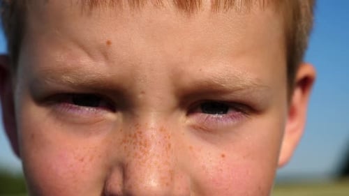 Child Squinting Outdoors Close Up on Face