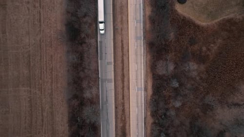 top down of a white Semi-trailer truck speeds on ramp enetering Interstate-highway I-94 Illinois. Ti