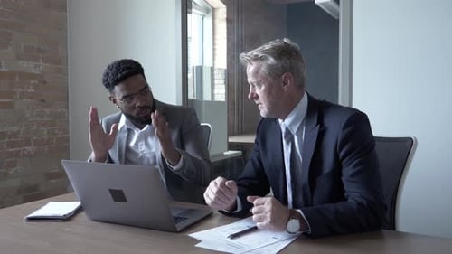 Businessmen Working Together on Laptop in Office